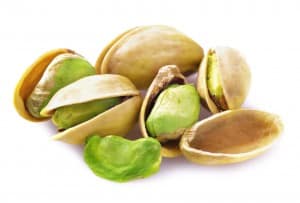Close up of a handful of pistachios on a white background