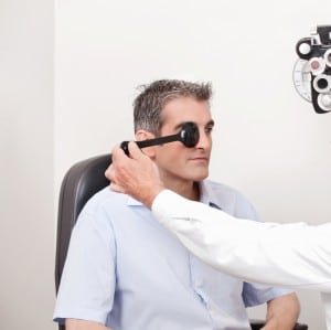 Middle aged man taking an eye exam at a doctor's office