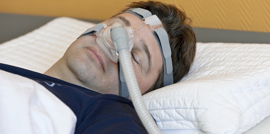 Man sleeping while wearing a CPAP mask.