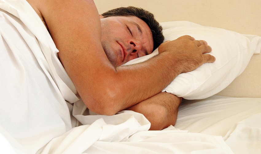 mature man sleeping on white pillow in bed