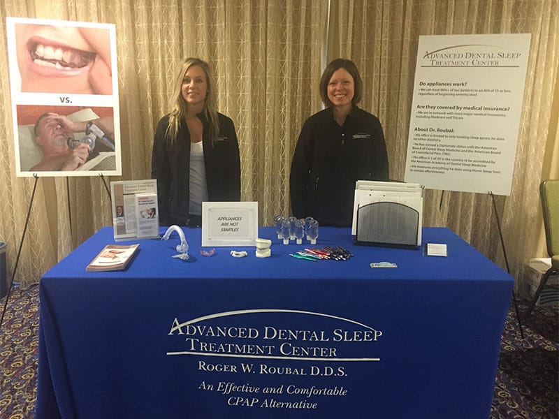 Staff members of Advanced Dental Sleep Treatment Center displaying their booth at a conference