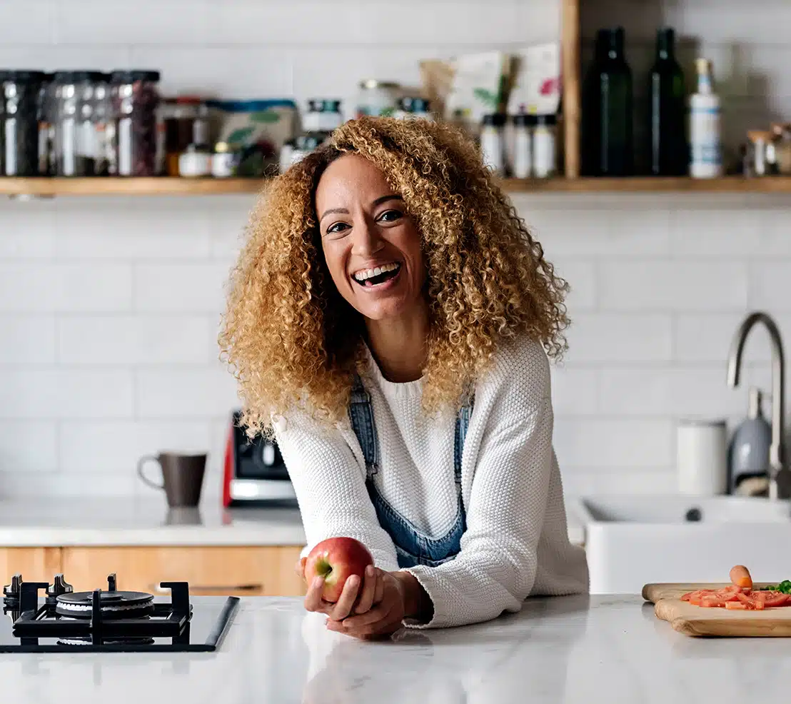 For Patients Sheets content woman standing in kitchen with big, wide smile