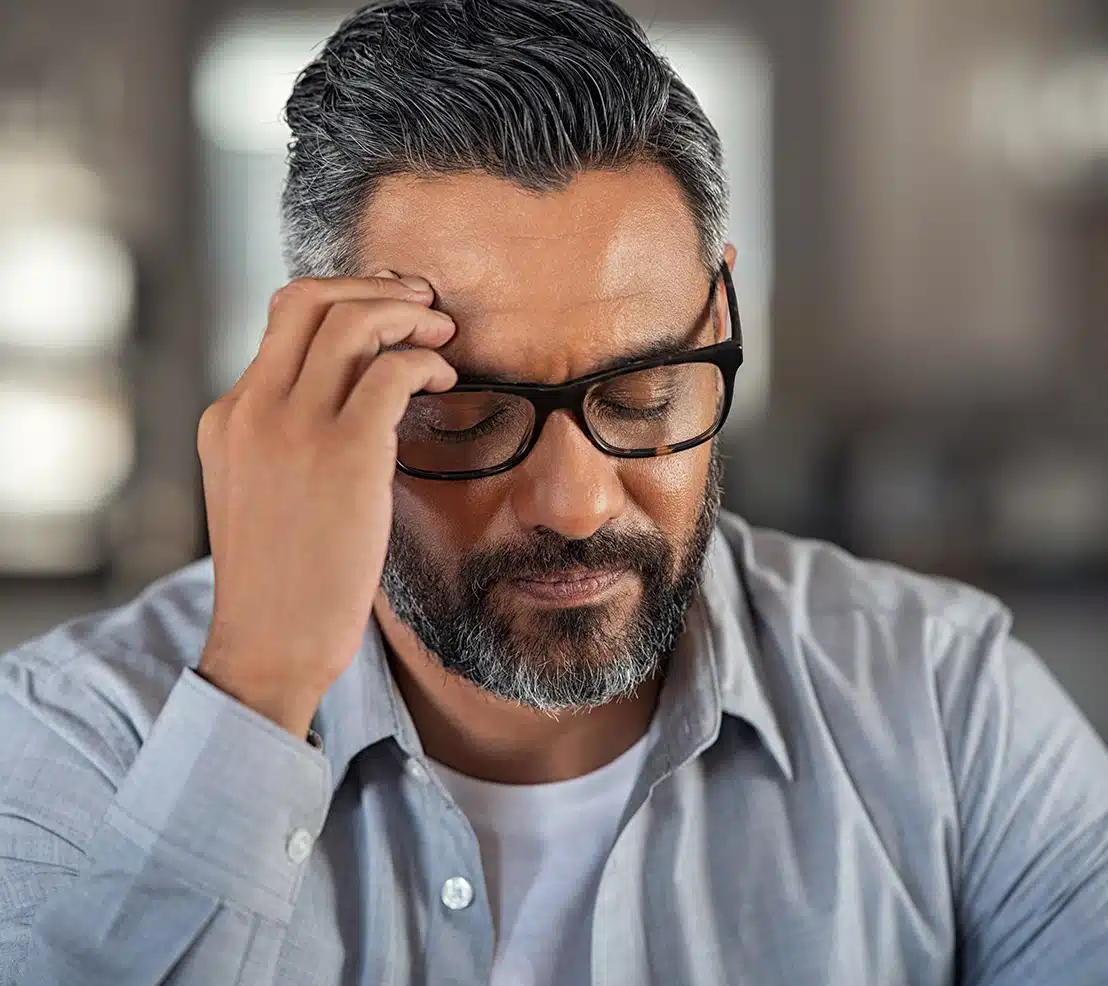 Headaches and Migraines Tired man rubbing his forehead, experiencing fatigue