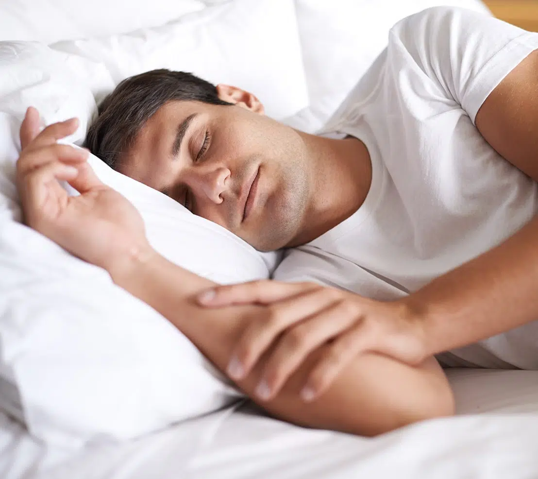 Peaceful man sleeping on his side, a recommended position for sleep apnea.
